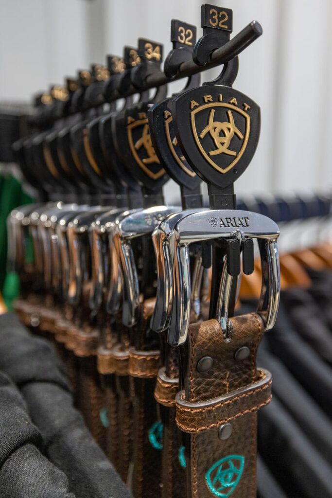 A row of Ariat leather belts featuring a horse logo at World Equestrian Center in Ocala, Florida