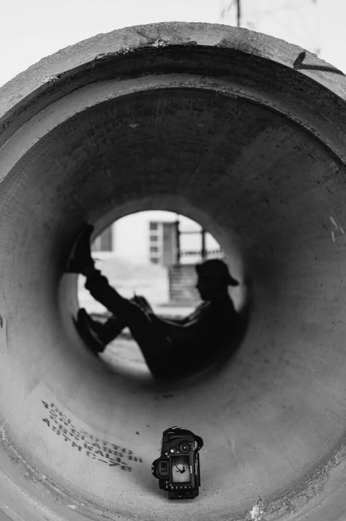 Behind-the-scenes shot of a photoshoot inside a pipe at Seminole Feed in Ocala, Florida.