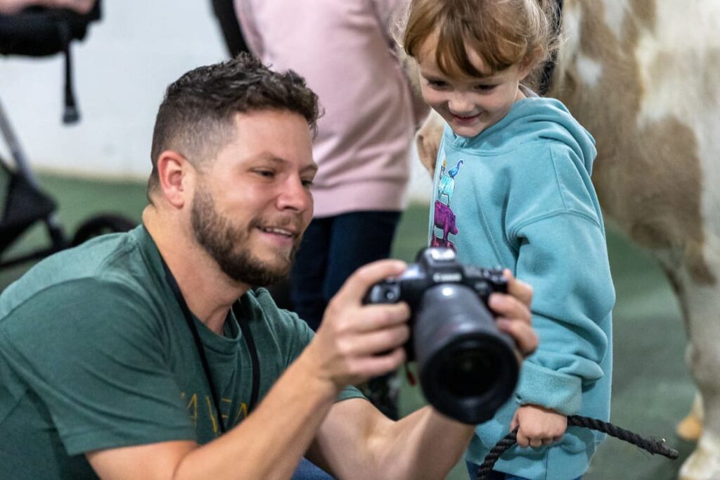 Maven Photo + Film showing a child a picture that they took.