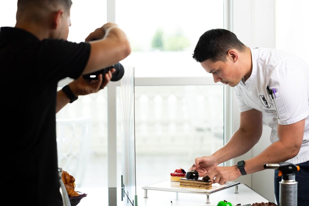 Team Maven taking pictures of a cook dressing a dessert plate at the World Equestrian Center