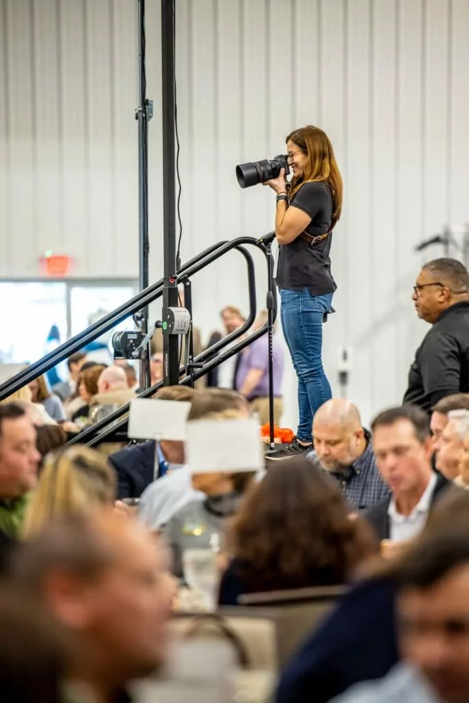 Meagan Gumpert standing on a podium to get the perfect photo at a live event in Ocala, Florida.