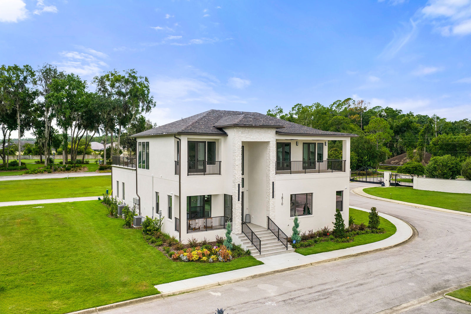 Oblique drone photograph of the Livingston Park residence showing its roofline, balconies, lawn, and surrounding streets
