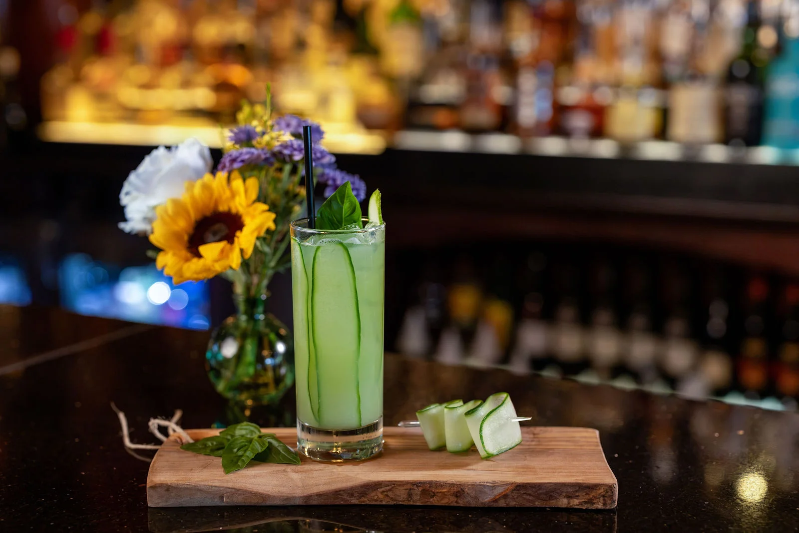 Green cocktail with cucumber ribbons and fresh herbs on the bar at Mark’s Prime in Ocala