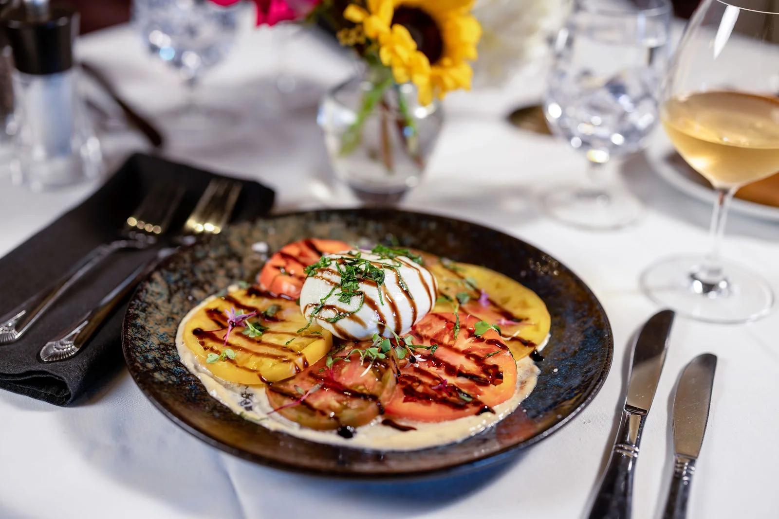 Burrata over red and yellow tomatoes with balsamic drizzle at Mark’s Prime Steakhouse